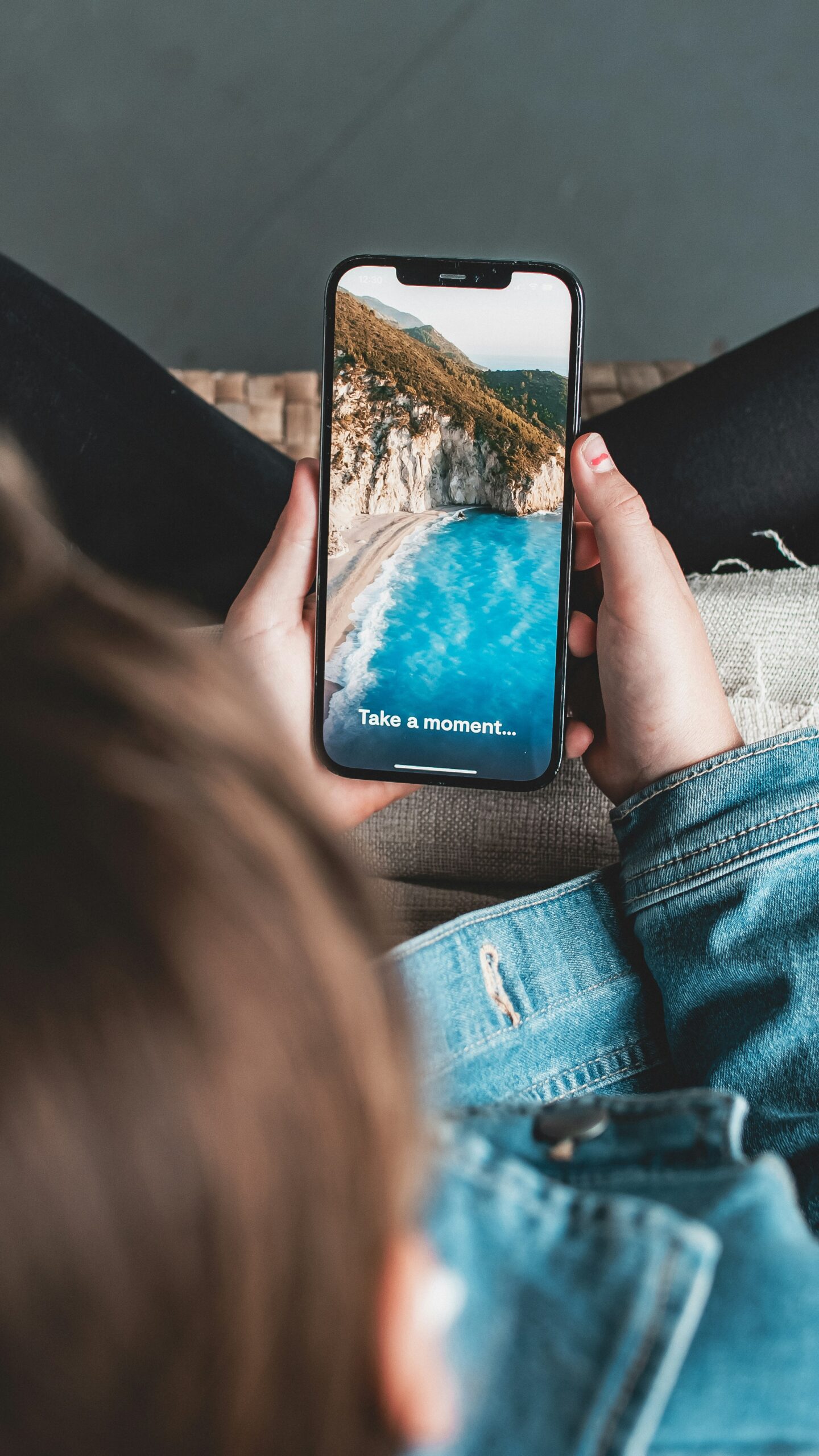 a person sitting on a couch holding a cell phone