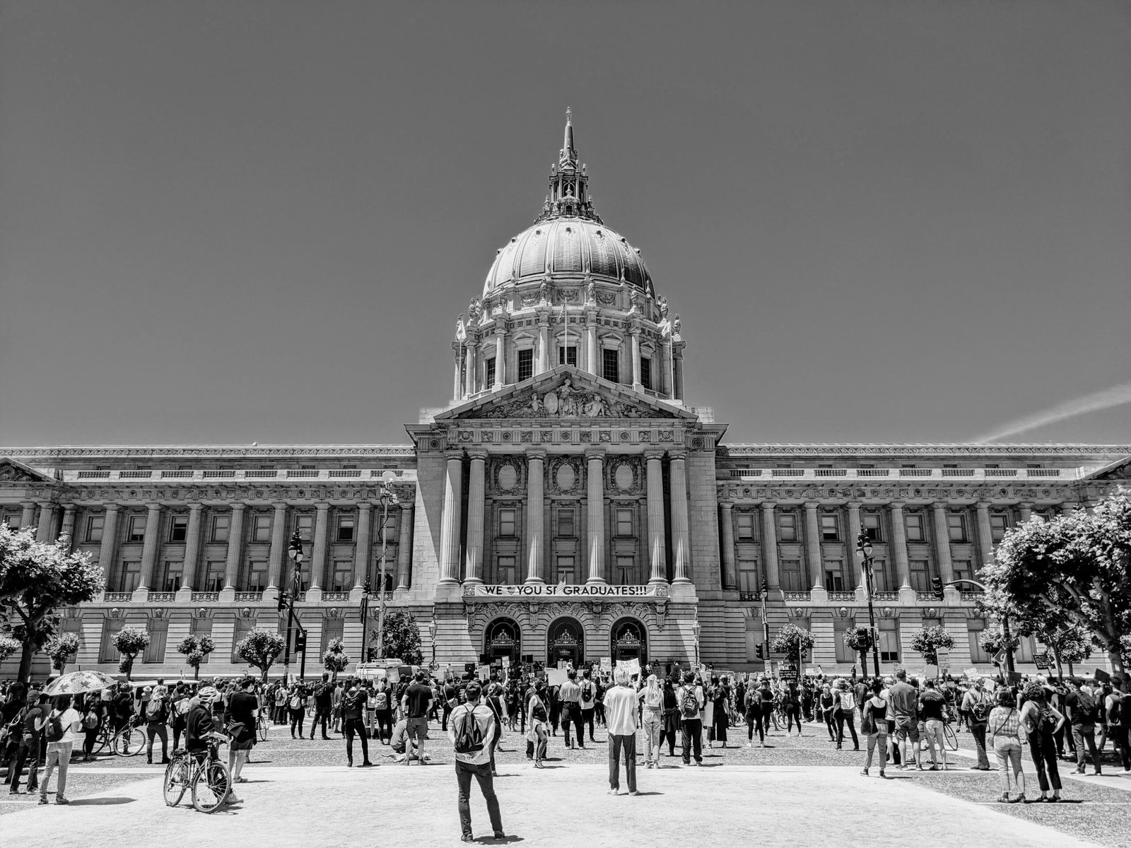 grayscale photo of people walking near building